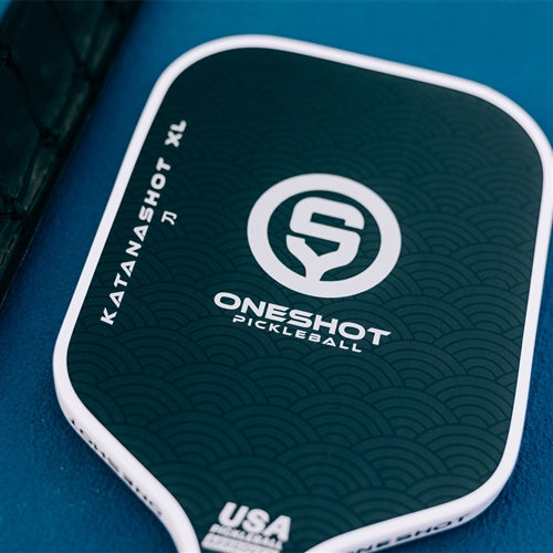 Katanashot XL Paddle by Oneshot Pickleball featuring a black carbon face and white logo, edge guard, and grip