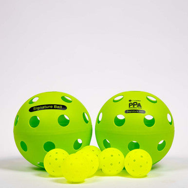 Side-by-side of The Signature Giant Pickleball next to standard sized pickleballs and The PPA Giant Pickleball.